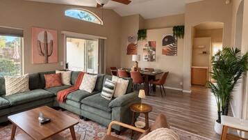 A spacious living room with a sectional sofa, a wooden coffee table, and a patterned rug.