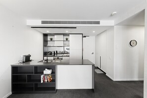 A modern kitchen with a central island, built-in appliances, and a minimalist design. - Executive 2-bed Apartment Near Kingston Hub (Canberra)
