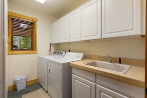 A laundry area with a washing machine, dryer, and a sink with a window above. - Peak 7 Cabin w/ Ten Mile Range Views, Fireplace (Breckenridge)