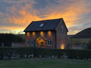 A two-story house with a sloped roof, a visible chimney, and a small window on the upper floor. - Little Red Barn (Shrewsbury)