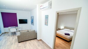 A modern hotel room with a bed, a desk, a sofa, and a TV. - Vrbo Property (Cartagena de Indias)