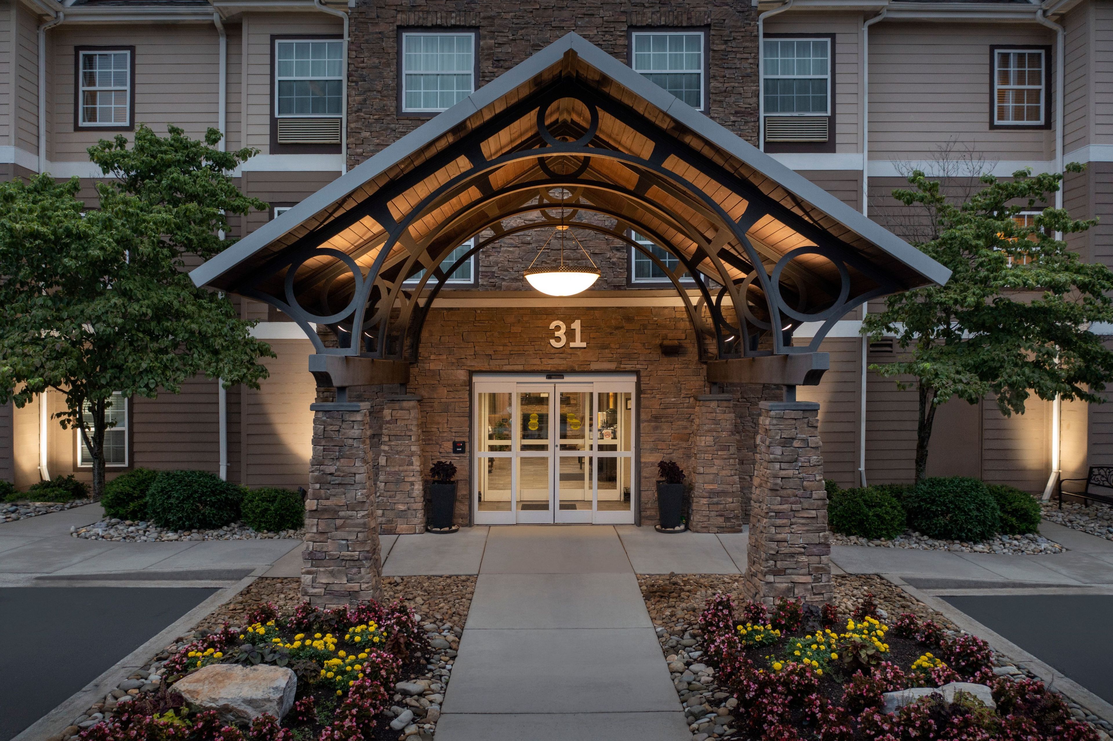 A building entrance with a stone facade, a number '31' above the door, and a covered walkway.
