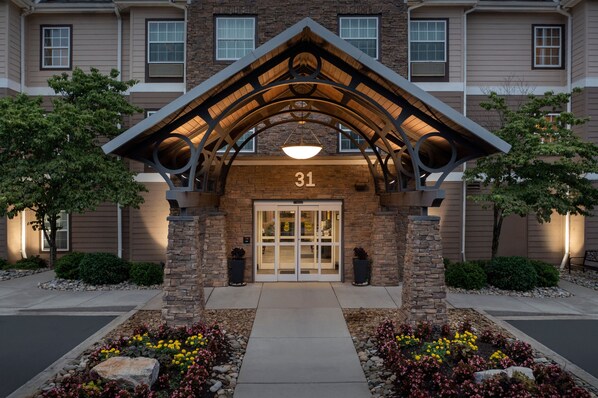 A building entrance with a stone facade, a number '31' above the door, and a covered walkway.
