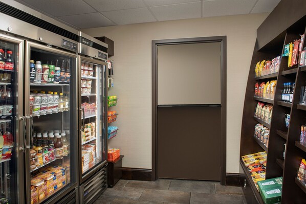 A refrigerated beverage area with shelves stocked with various drinks and snacks.