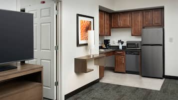 A compact kitchen with a refrigerator, microwave, coffee maker, and a small countertop.