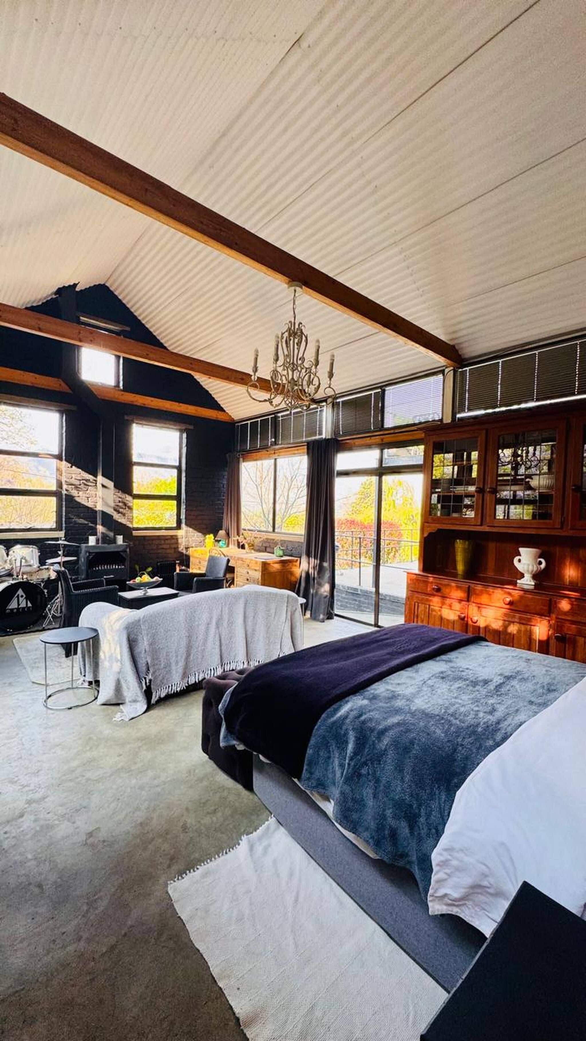 Une chambre spacieuse avec un grand lit, un bureau et une vue sur l’extérieur.