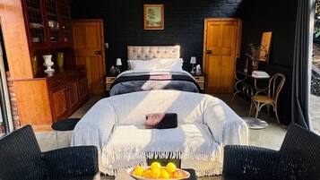 Un dormitorio amplio con una cama grande, una araña y vistas al exterior.