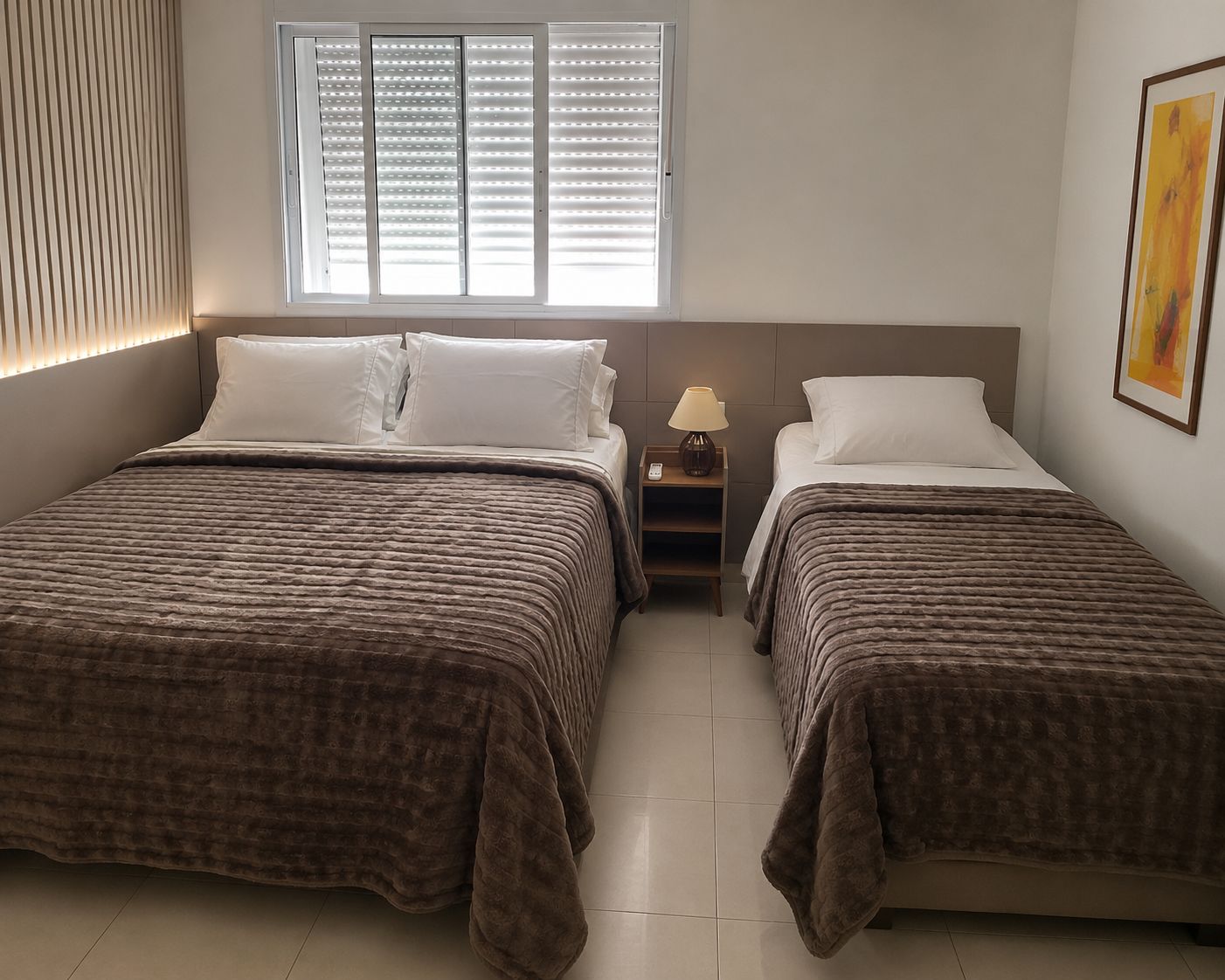 A hotel room with two beds, a nightstand, a window with blinds, and a painting on the wall.