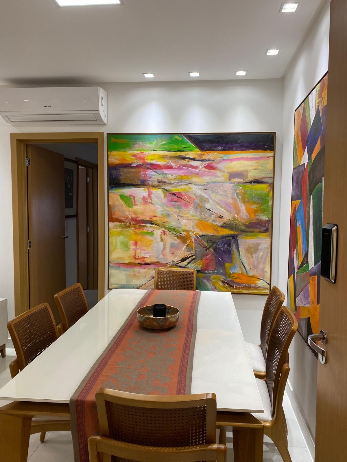 A conference room with a long table, chairs, and a large abstract painting on the wall.