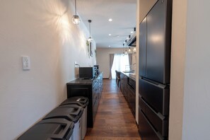 A narrow kitchen with a built-in dishwasher, a refrigerator, and pendant lighting. - Villa Arco Miyakojima (Miyakojima City)