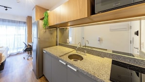 Una cocina moderna con refrigerador de acero inoxidable, encimera de granito y lavavajillas integrado.