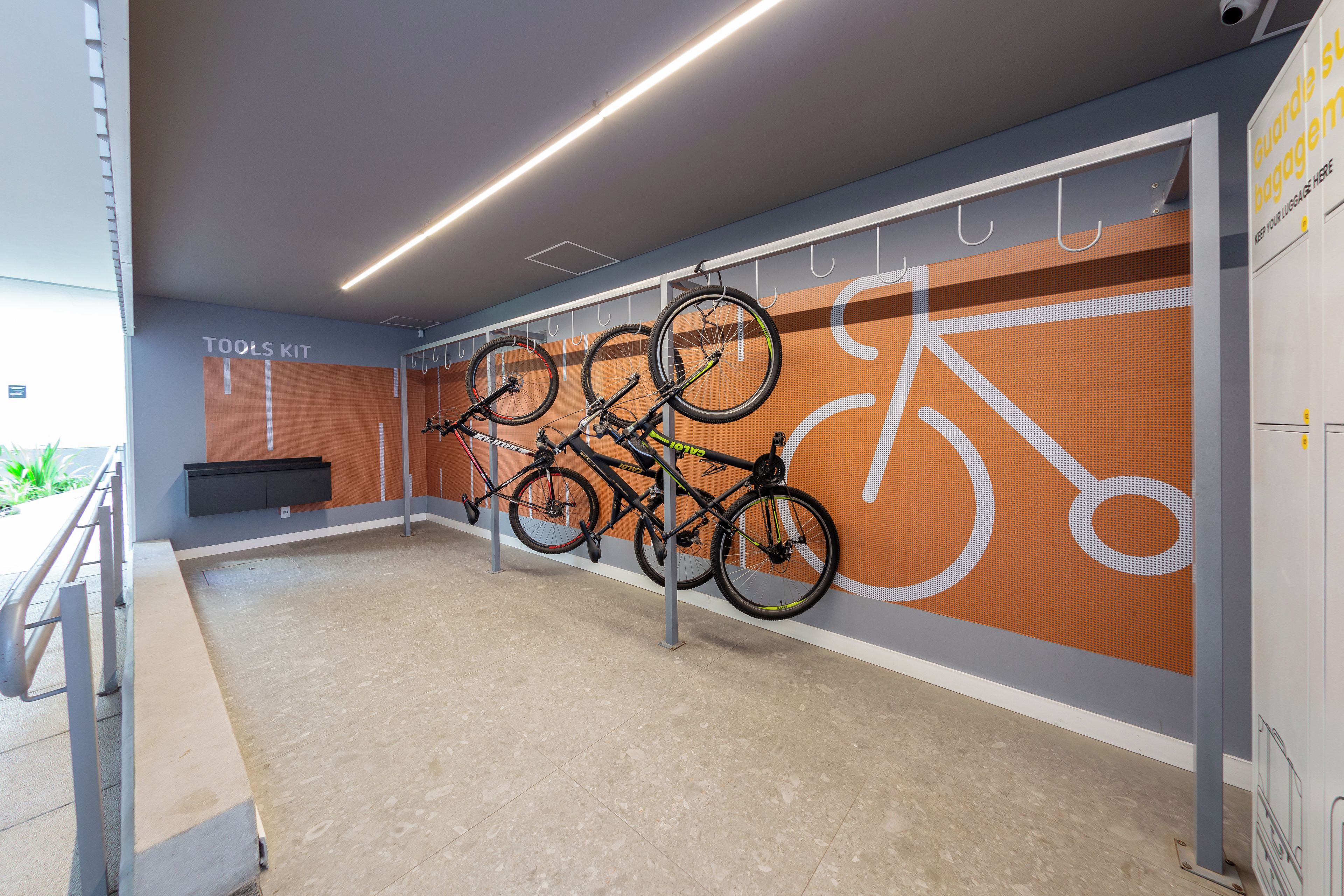 Un espace de stockage pour vélos où plusieurs vélos sont fixés à des crochets.