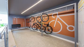 Un espace de stockage pour vélos où plusieurs vélos sont fixés à des crochets.