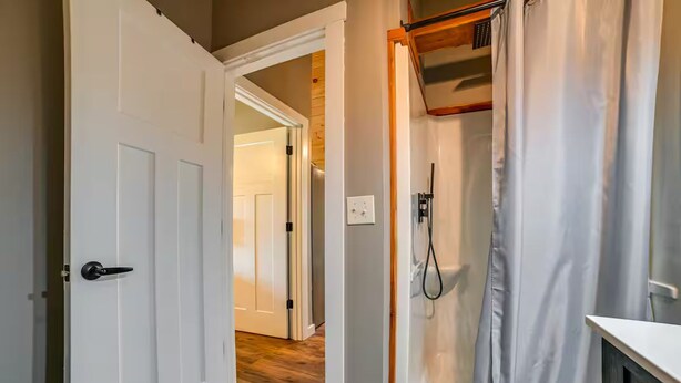 Et badeværelse med bruser, toilet og vask.