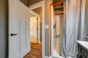 A bathroom with a shower, a toilet, and a sink.