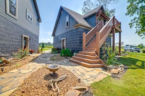 A two-story house with a stone pathway leading to a wooden staircase. - Riverfront Living (Clifton)