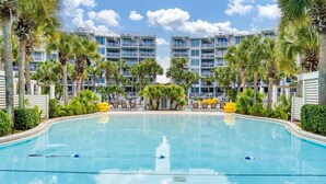 A swimming pool with a clear view of a hotel building in the background. - Gulf View Corner Condo + Lazy River + Beach Chairs (Fort Walton Beach)