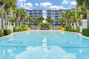 A swimming pool with a clear view of a hotel building in the background. - Gulf View Corner Condo + Lazy River + Beach Chairs (Fort Walton Beach)