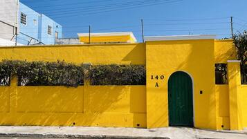 A yellow building with a green door and the number 140A.