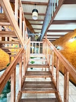 A wooden staircase with a metal railing, leading to a higher floor.