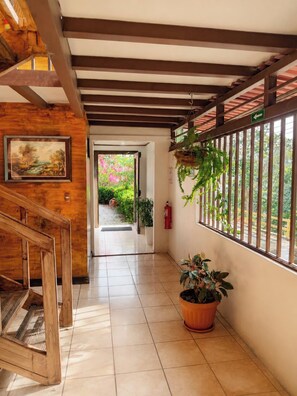 A wooden staircase leading to a room with a view of a garden.