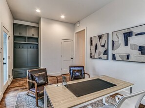 Ein Zimmer mit Esstisch, zwei Stühlen, Kleiderständer und Garderobe.