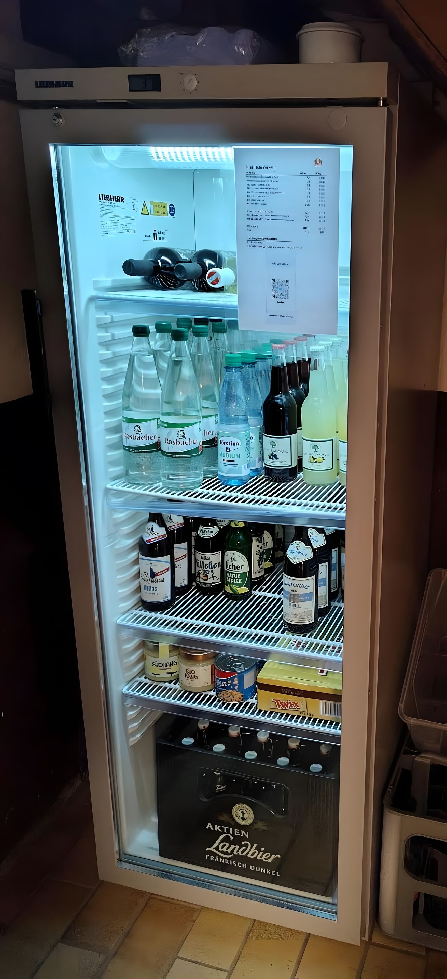 Un refrigerador lleno de diversas bebidas y alimentos.