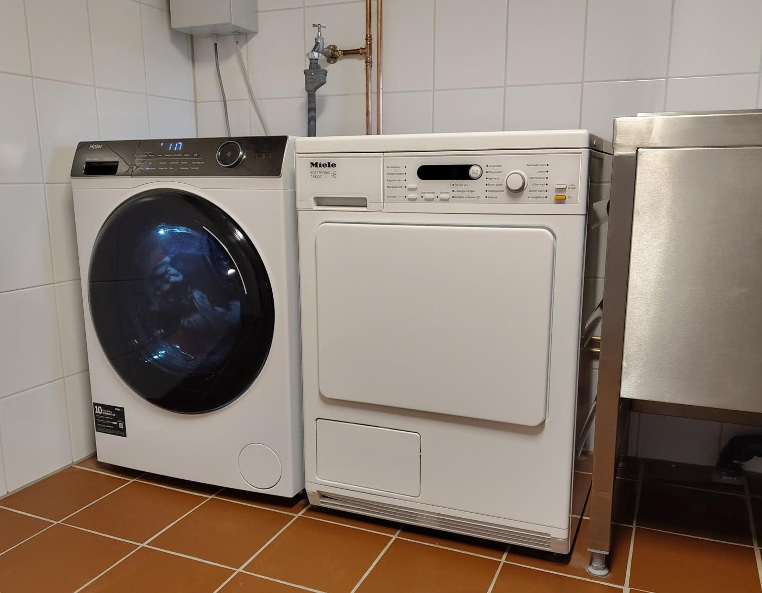 Ein Waschraum mit einer Waschmaschine mit Frontlader und einem Trockner.