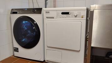 Ein Waschraum mit einer Waschmaschine mit Frontlader und einem Trockner.
