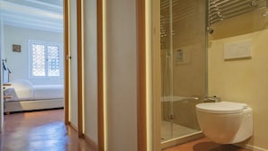 A modern bathroom with a glass shower enclosure, a toilet, and a visible towel rack. - STUNNING DORSODURO HOME WITH SECRET GARDEN & TWO PRIVATE TERRACES (Venezia)
