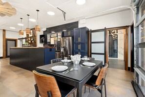 Cocina moderna con armarios oscuros, electrodomésticos de acero inoxidable y una isla central.