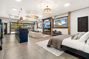 Un dormitorio moderno con una cama grande, chimenea y televisor montado en la pared.