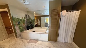 A bathroom with a marble floor, a bathtub, and a shower curtain. - The Perfect Gettysburg Escape - Room #14 at The Inn At Herr Ridge (Gettysburg)