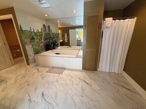 Ein Badezimmer mit Marmorboden, einer Badewanne und einer Duschvorhang.