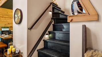 Una escalera con barandilla de madera y un reloj en la pared.