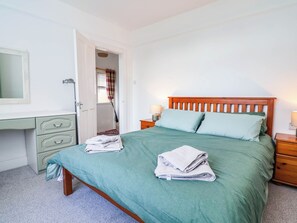 A bedroom with a bed, a nightstand, a dresser, and a mirror. - 29 Brynford (Ellesmere Port)
