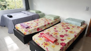 A room with two single beds, each with a floral bedspread and a pillow. - Off Road House (Ibicoara)