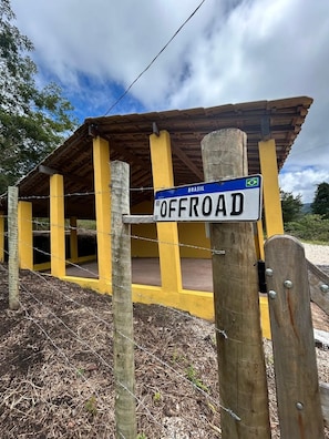 Un espacio al aire libre techado con un cartel que dice 'OFFROAD BRASIL' y una valla de madera.