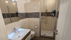 Un baño moderno con ducha, inodoro y lavamanos.