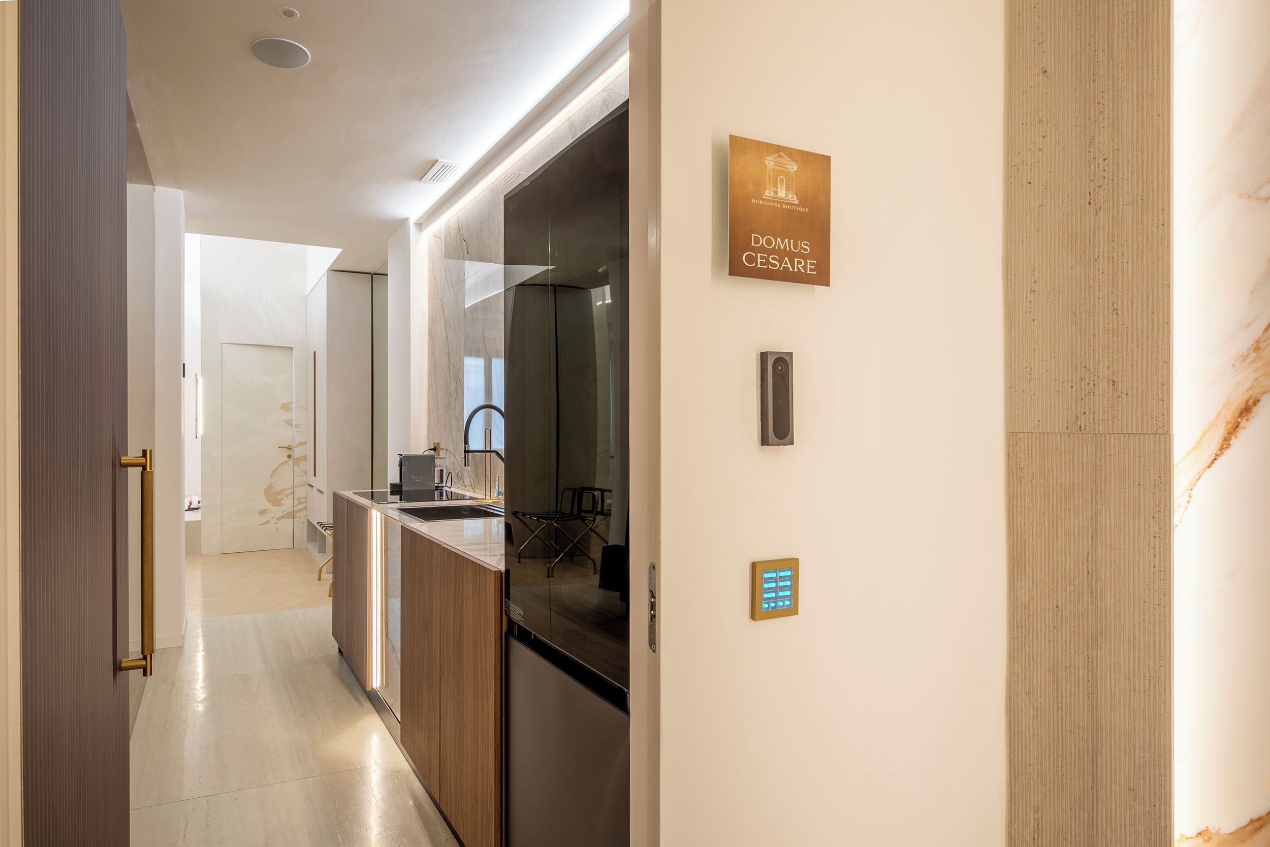 Una cocina moderna con horno empotrado, un lavamanos y una zona de comedor con una silla.