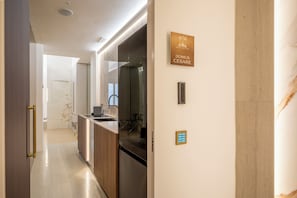 A modern kitchen with a built-in oven, a sink, and a dining area with a chair. - Borghese Boutique (Rome)