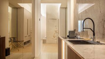 A modern kitchen with a marble countertop, a black faucet, and a built-in oven.
