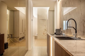 A modern kitchen with a marble countertop, a black faucet, and a built-in oven. - Borghese Boutique (Rome)