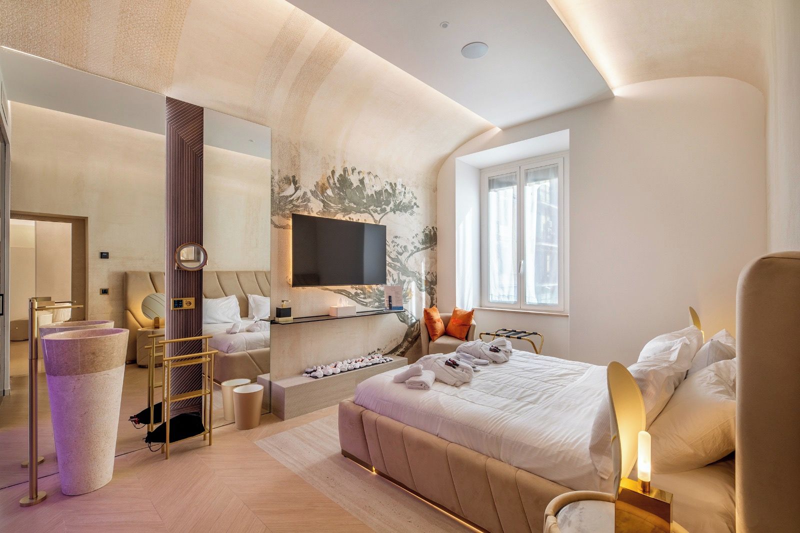 Habitación de hotel moderna con una cama grande, televisión, espejo y ventana con cortinas.