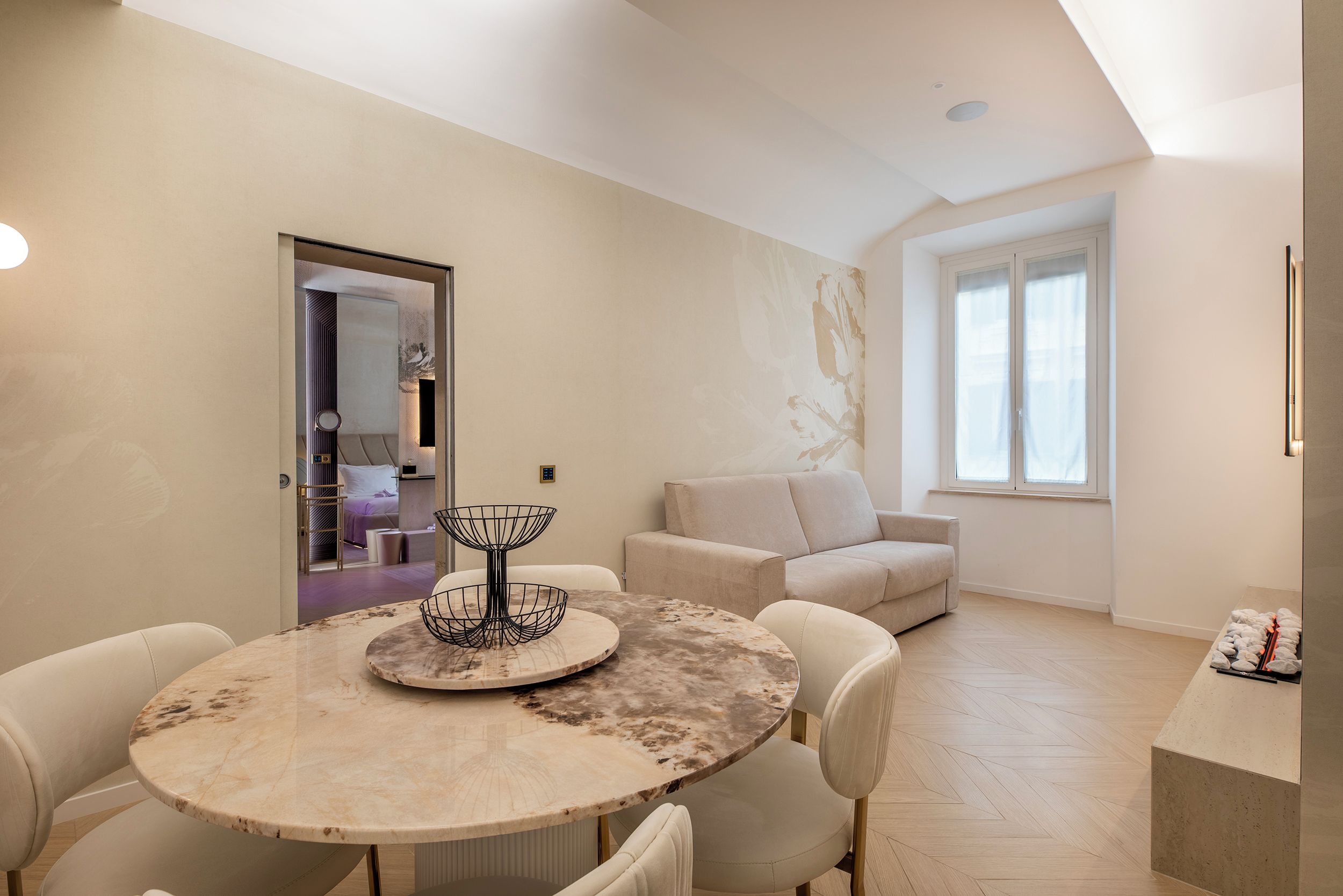 Un salon moderne avec une table ronde en marbre, un canapé et une fenêtre.