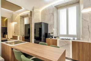A modern kitchen with a marble backsplash, a built-in oven, and a large window. - Borghese Boutique (Rome)