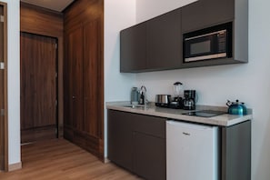 Eine kleine Küche mit Mikrowelle, Kaffeemaschine und kleinem Kühlschrank.