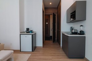 A compact kitchen with a refrigerator, microwave, and coffee maker. - Condesa Residence - Roma Luxury Suite 503 (Mexico City)