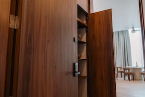 A wooden cabinet with multiple shelves, a small table with chairs, and a window with curtains. - Condesa Residence - Roma Luxury Suite 303 (Ciudad de México)