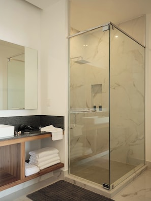 A modern bathroom with a glass-enclosed shower, a vanity with a marble countertop, and a large mirror. - Condesa Residence - Roma Luxury Suite 604 (Mexico City)